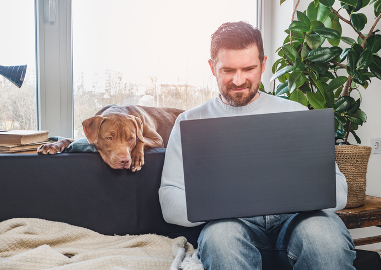 Man on laptop with his dog