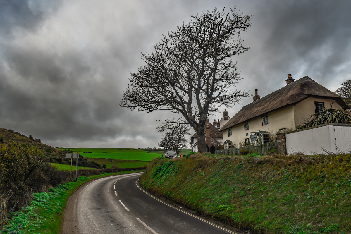 A corner of a rural road with a house at the side of the road in a country side setting