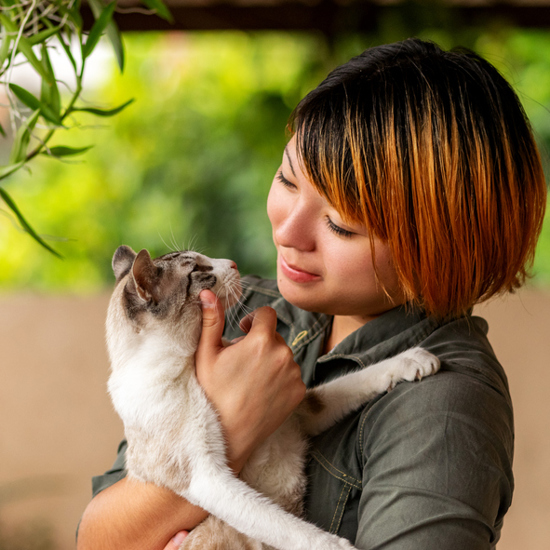 A woman holding a cat in her arms