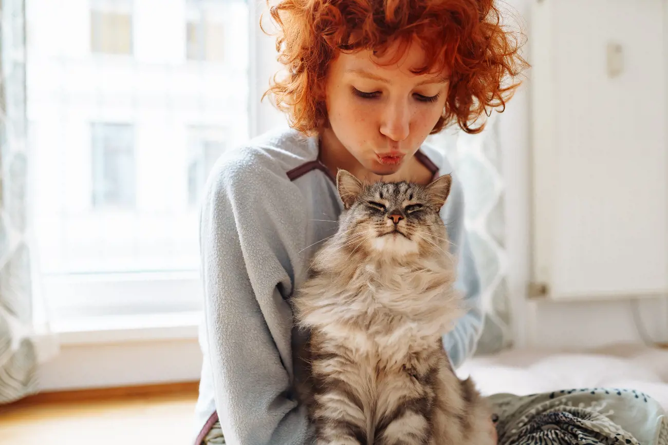 woman kissing a cat's head