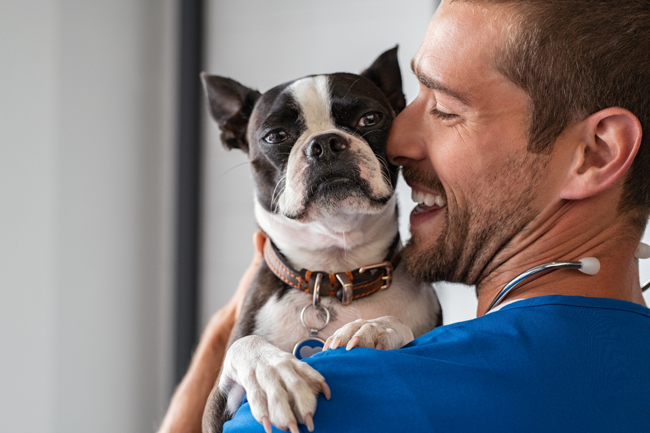 man hugging boxer dog