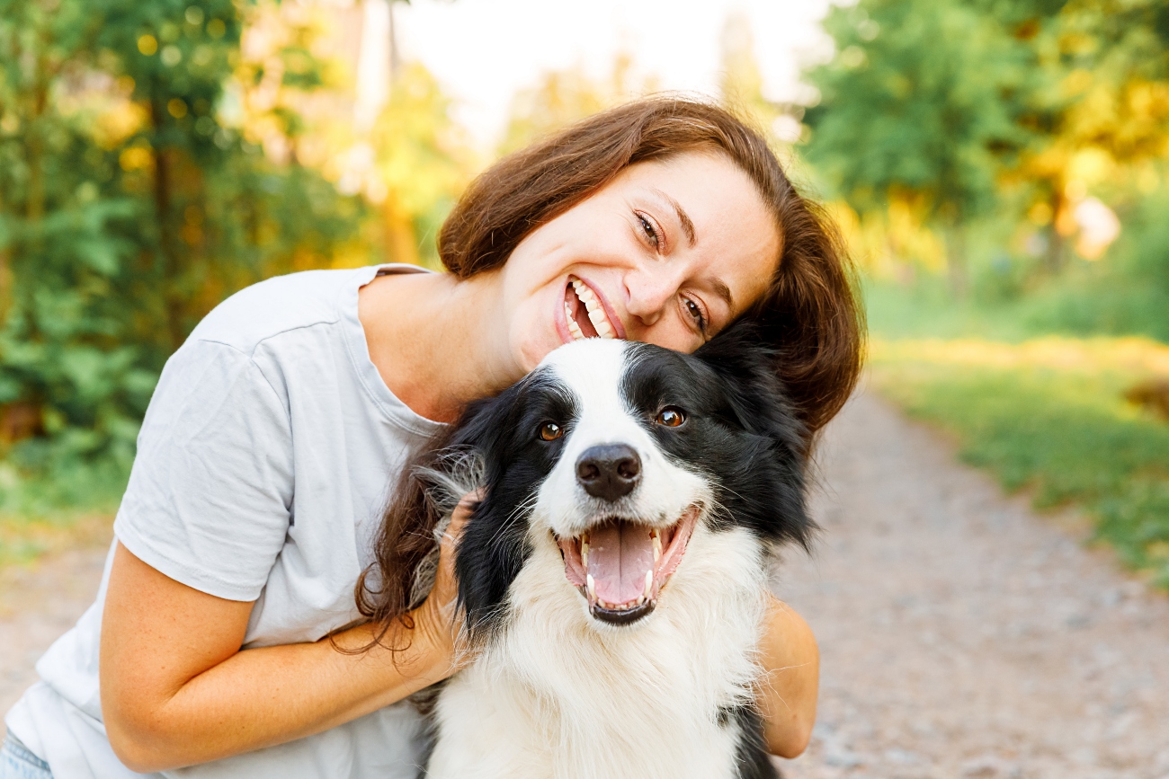 woman and black dog hugging eachother